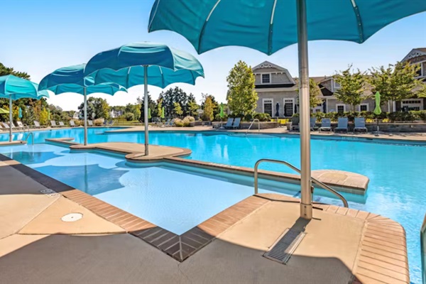 Adult-only hot tub surrounded by lounge seating and umbrellas—a serene spot for relaxation.