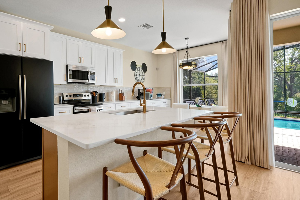 Kitchen: Fully renovated kitchen with island, seating for three and direct access to the private pool area.