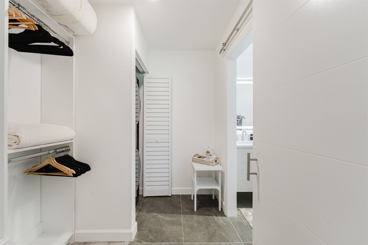 Spacious walk-in closet with built-in shelving, ample hanging space, and in-unit washer and dryer for ultimate convenience during your stay.