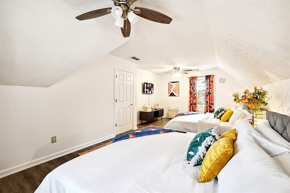 Bedroom 2 is located upstairs and features two king beds and a TV. This room does not have a private en-suite bathroom but has access to a shared full bathroom on the second floor.