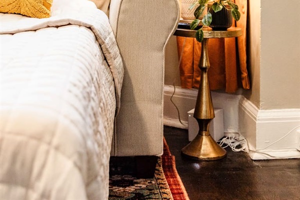 Cozy sofa bed with a side table and lamp, creating a comfortable and functional space for lounging, reading, or hosting overnight guests.