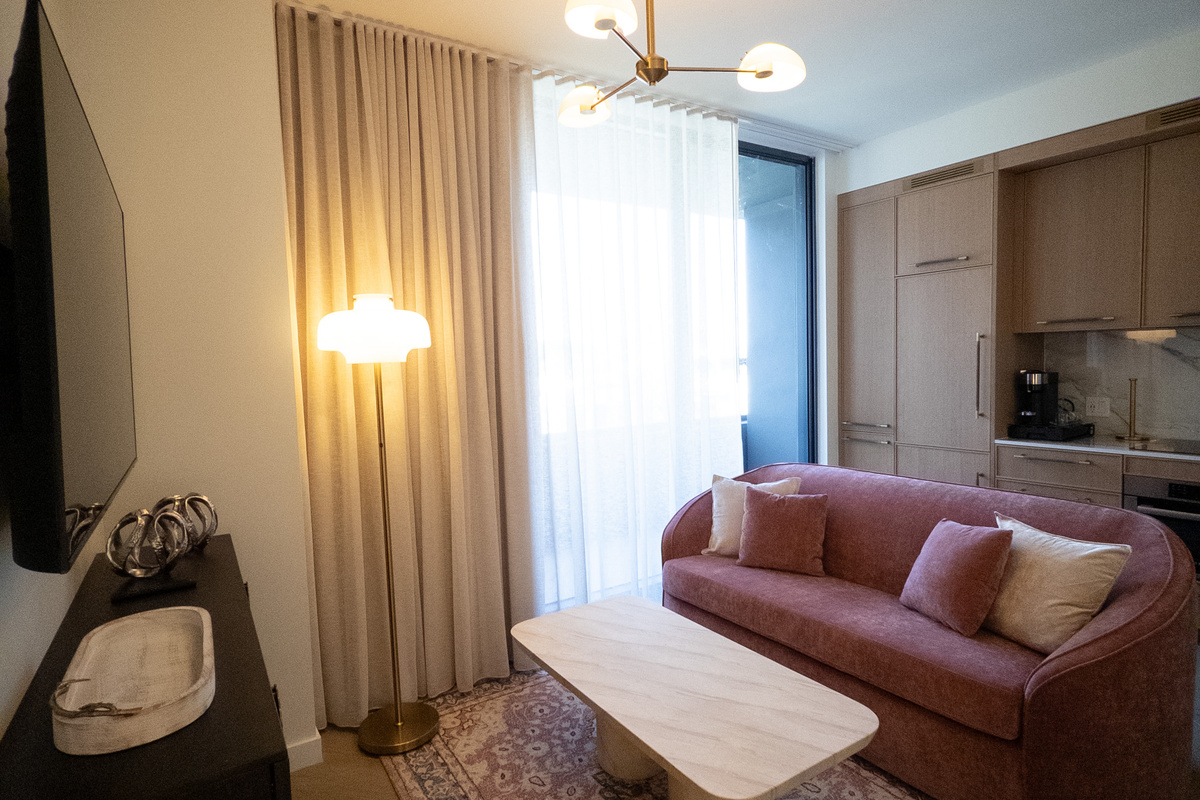 Light-filled living nook - plush sofa framed by floor-to-ceiling sheers for slow Miami mornings.