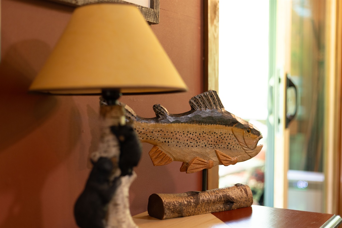 Rustic mountain touches like the bear lamp and trout décor add to the cabin’s cozy creekside charm.