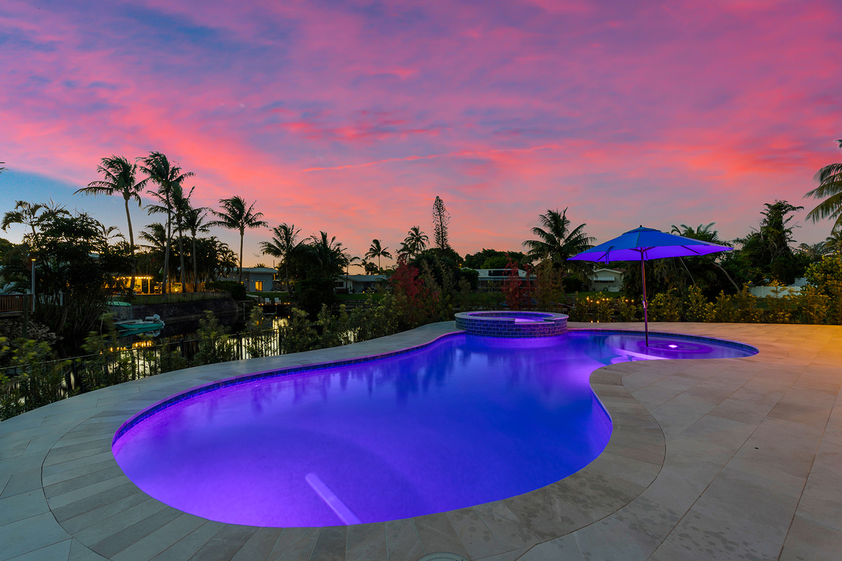 Sunset views, colorful skies, and a beautifully lit pool create an unforgettable waterfront experience.