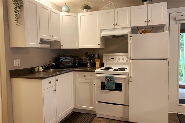Fully stocked kitchen with apartment size fridge, stove, microwave, blender, slow cooker, popcorn maker, and everything you would need for a stay of any length.