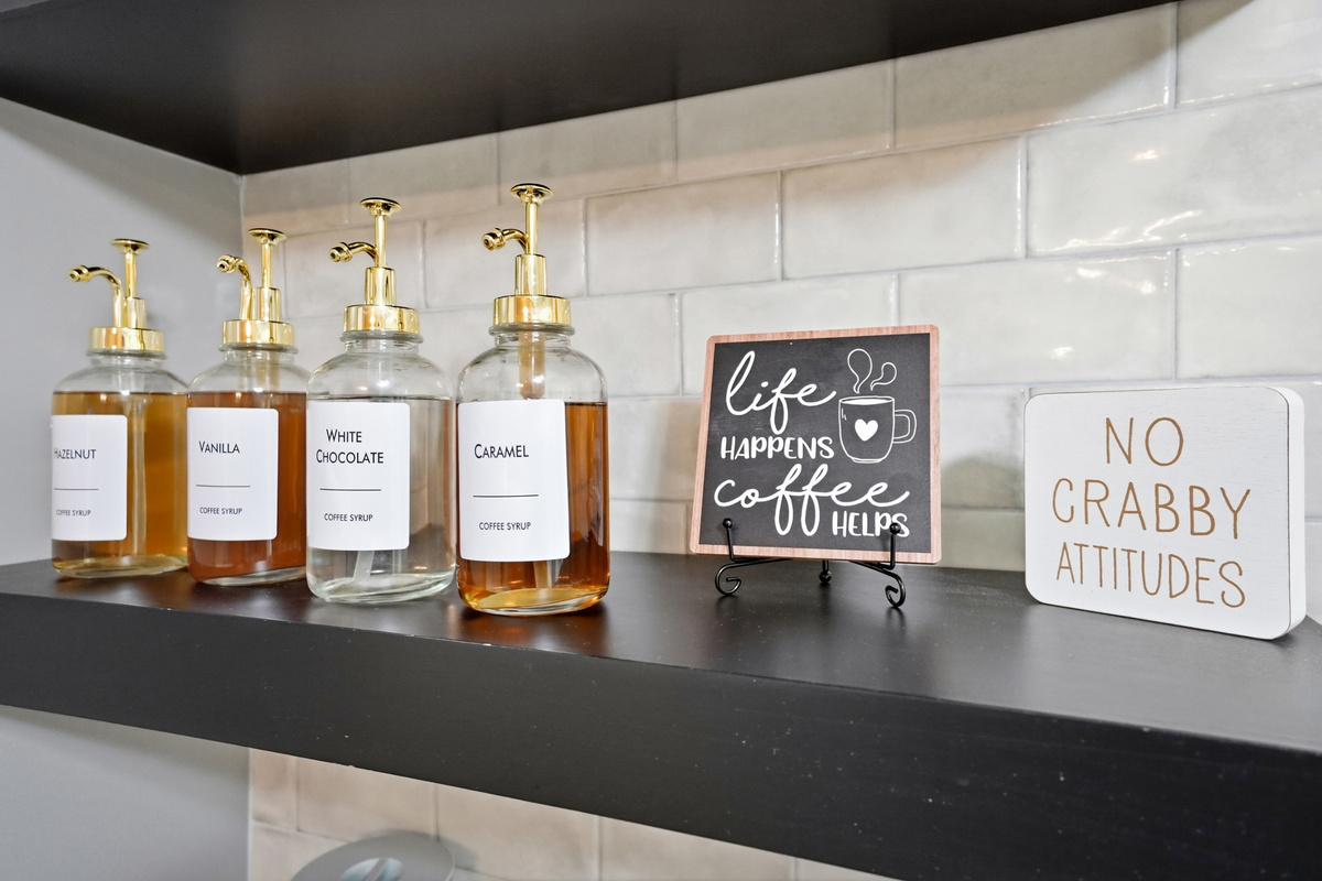 The kitchen includes a dedicated coffee bar beside the full-size refrigerator and additional storage.