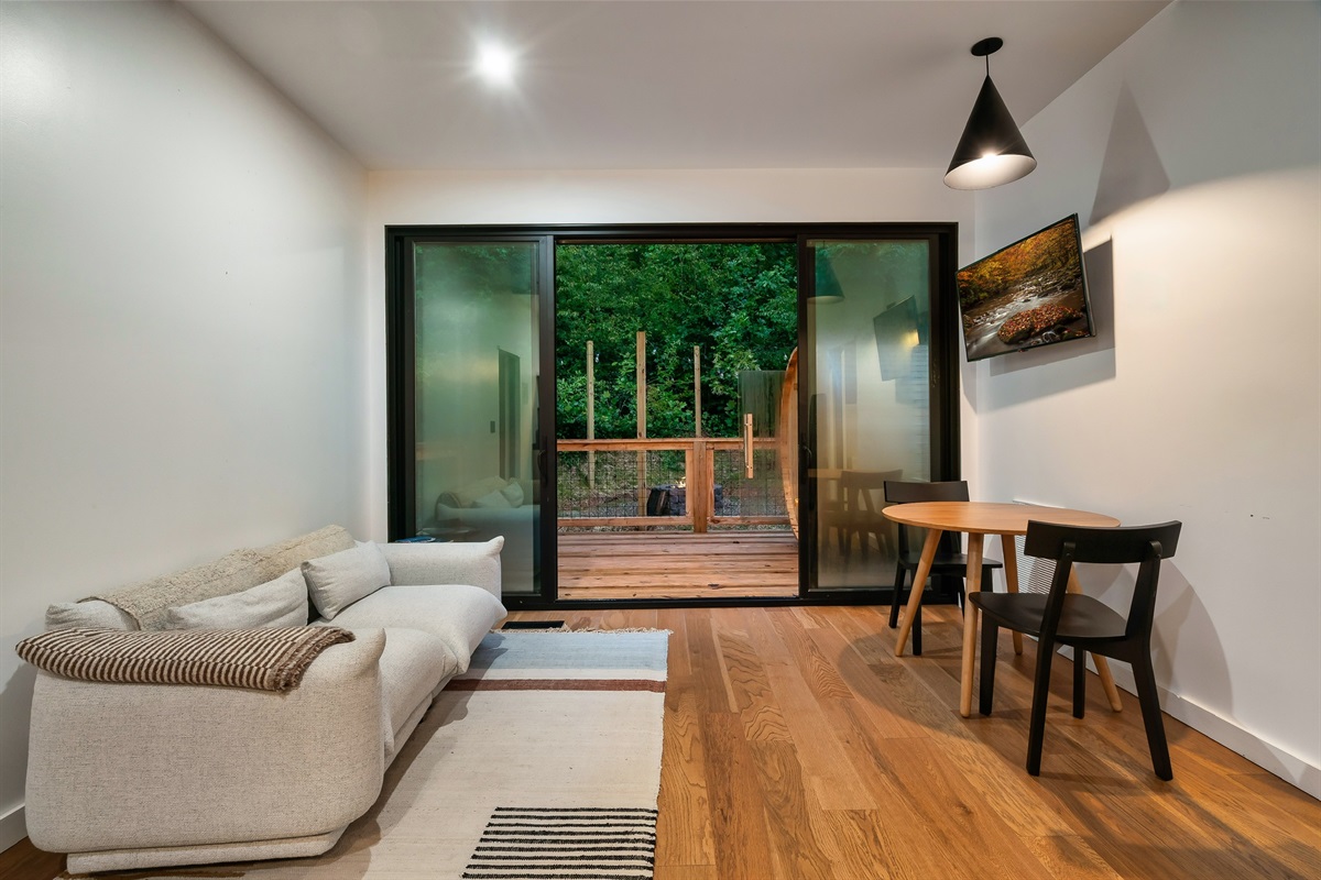 Main living area and dining area! TV on wall and sauna on deck outside.