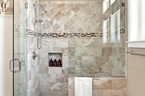 The glass-enclosed walk-in shower features detailed tilework for a clean, polished bathroom experience.