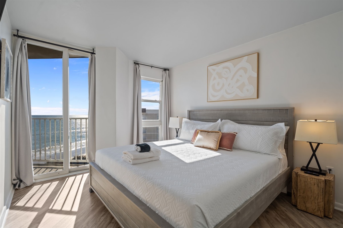 Wake up to ocean light: serene bedroom with plush linens and a private balcony view