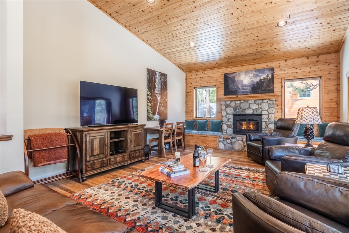Cozy living room with fireplace, ample seating and beautiful mountain views through the windows. A great place to relax after a day of winter activities!