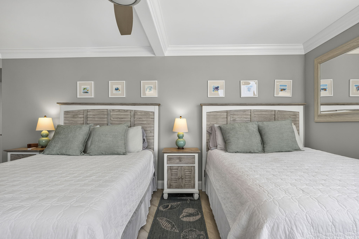 Guest bedroom with two full size beds and balcony access