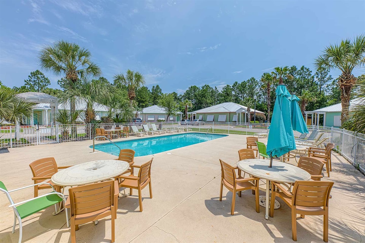 Poolside Paradise: Relax under vibrant umbrellas by the sparkling pool in sunny Orange Beach!