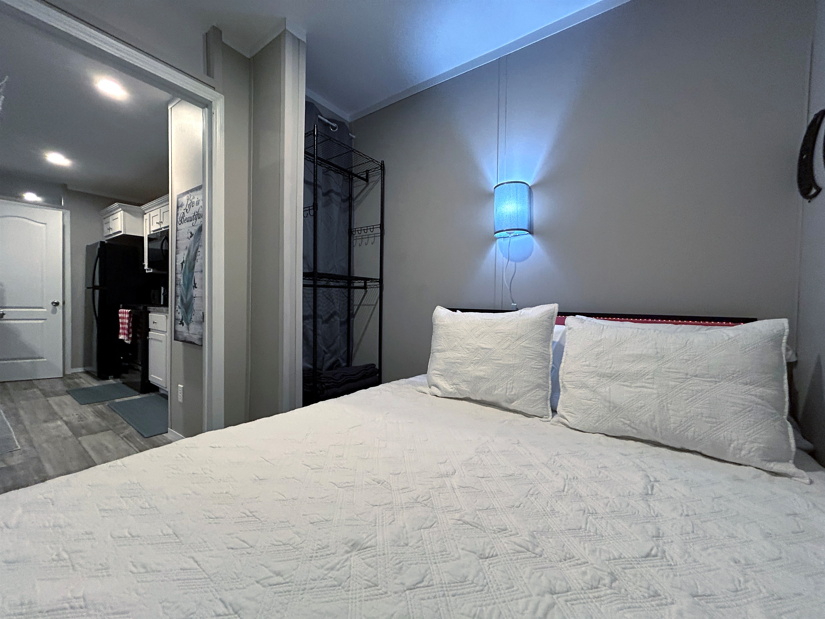 Bedroom #1 with queen bed, smart tv, en suite bathroom and hidden washer/dryer combo in closet