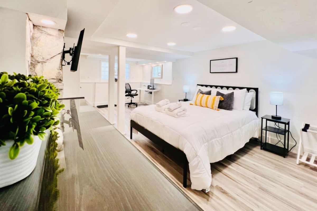 Spacious queen-sized bedroom with a dedicated working space and a TV, offering the perfect blend of comfort, productivity, and entertainment.