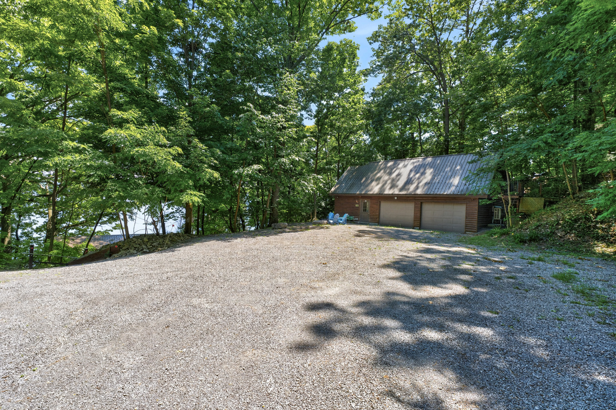Gravel parking area beside a wooded garage