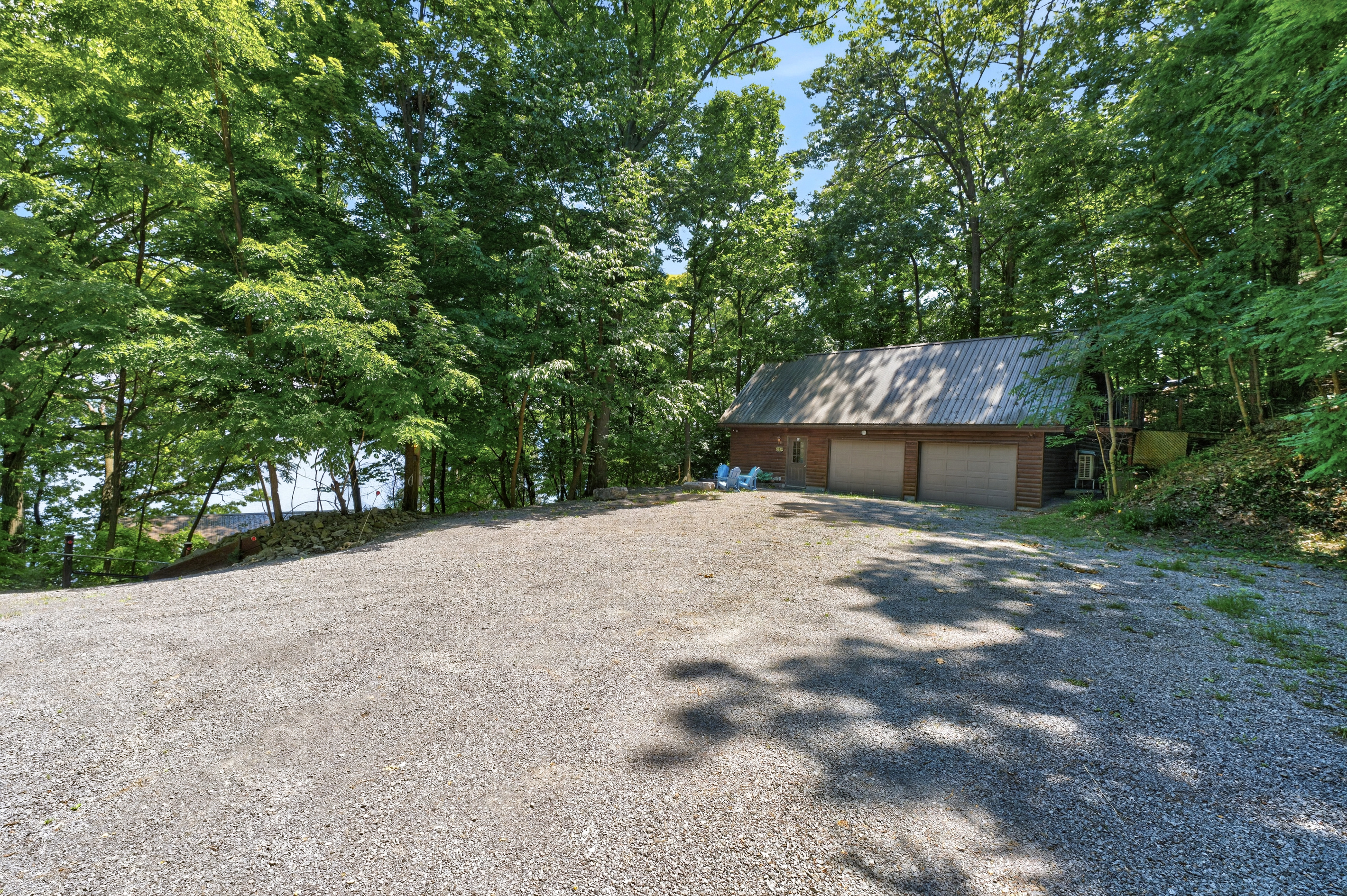 Gravel parking area beside a wooded garage