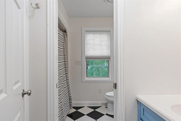 Designed for convenience, the upstairs shared bath features a separate vanity area with sink and mirror for getting ready, leading into a private bath space with a second sink, toilet, and shower.