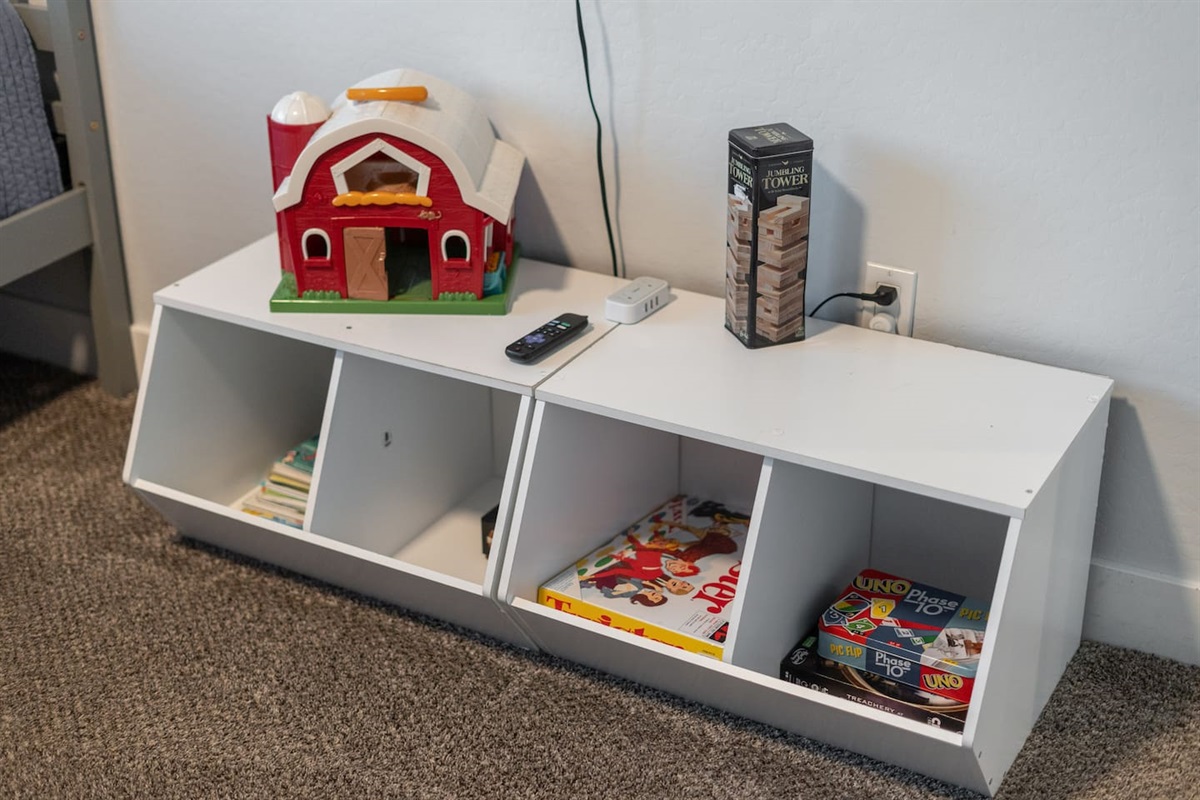 Charming cabinet with a collection of books and a toy barn, adding both style and fun to the room's decor.