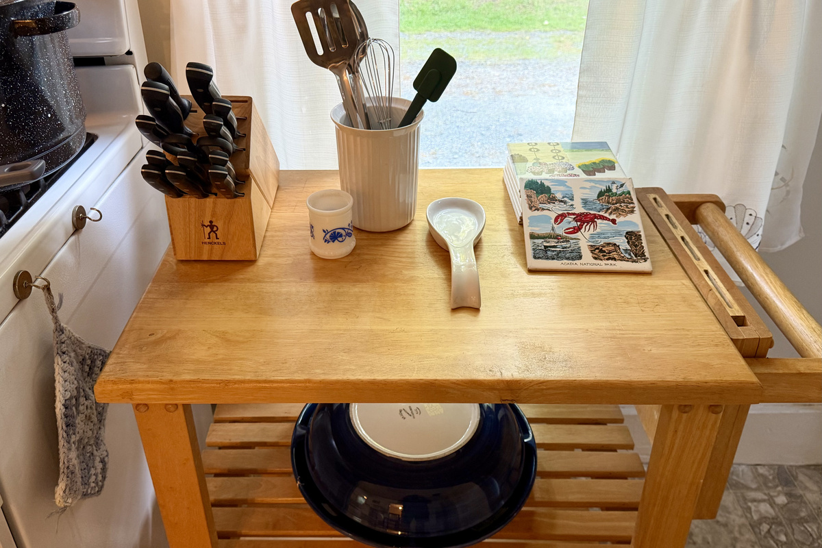 A closer look at your meal-prep station, complete with a rolling kitchen cart, premium J.A. Henckels knives, and custom Acadia National Park ceramic trivets. Thoughtful, quality touches to make your vacation cooking a breeze.