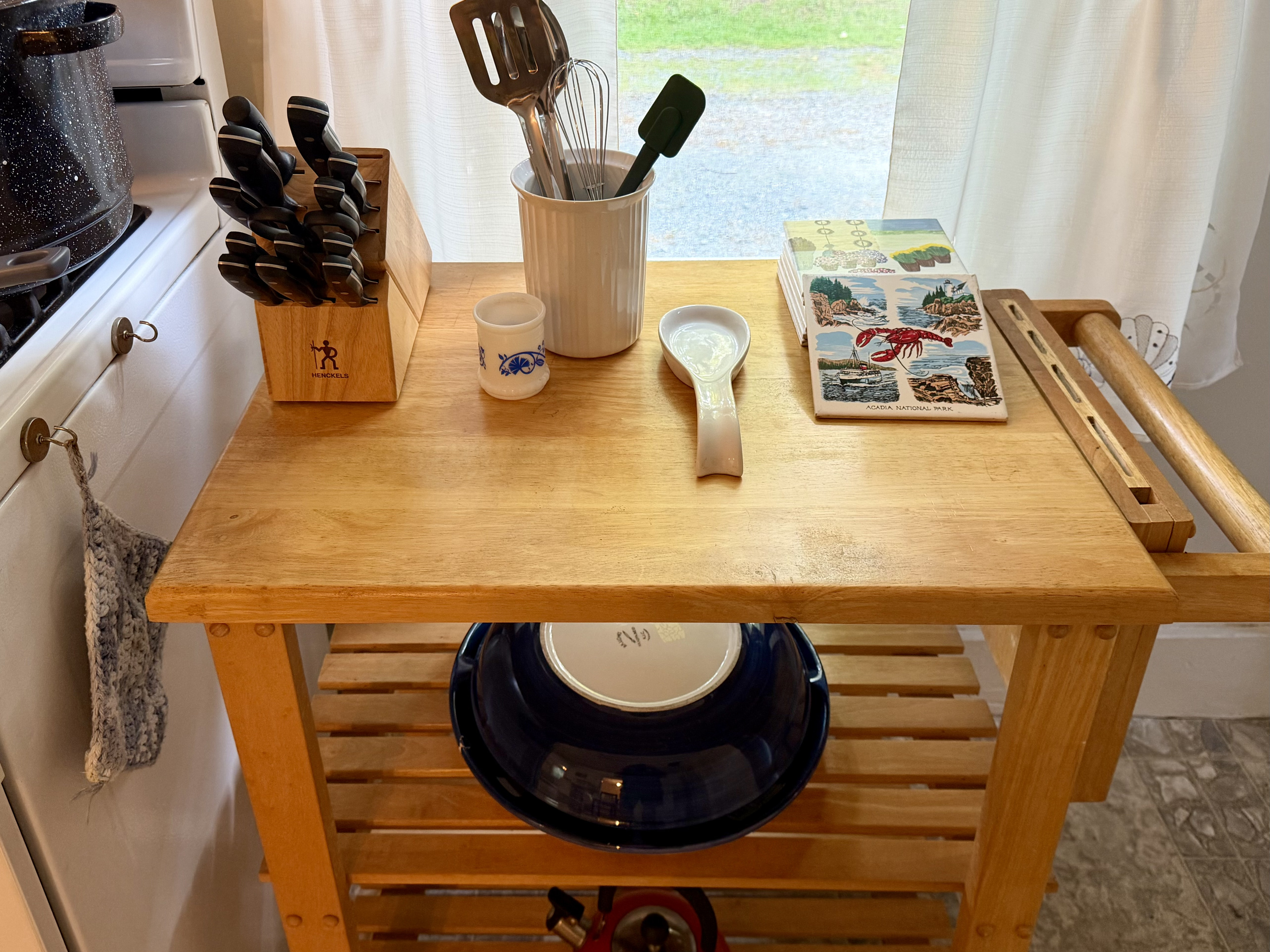 A closer look at your meal-prep station, complete with a rolling kitchen cart, premium J.A. Henckels knives, and custom Acadia National Park ceramic trivets. Thoughtful, quality touches to make your vacation cooking a breeze.