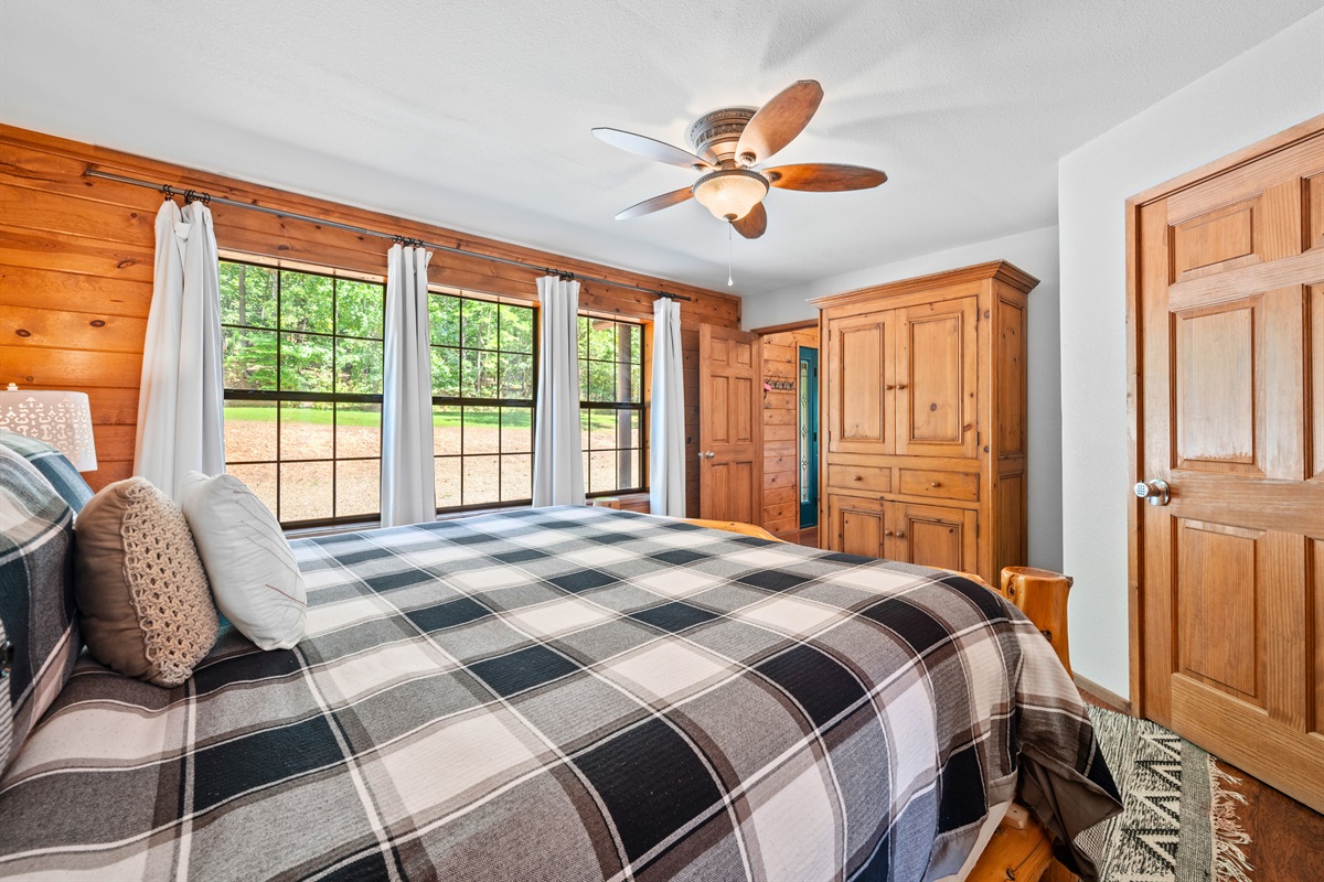 Enjoy peaceful forest views from bed through oversized windows.