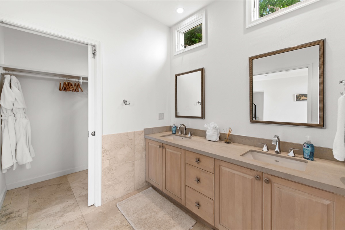 Modern bathroom with double vanity, hair dryer, walk-in shower, and spa-like vibes to refresh after a beach day.