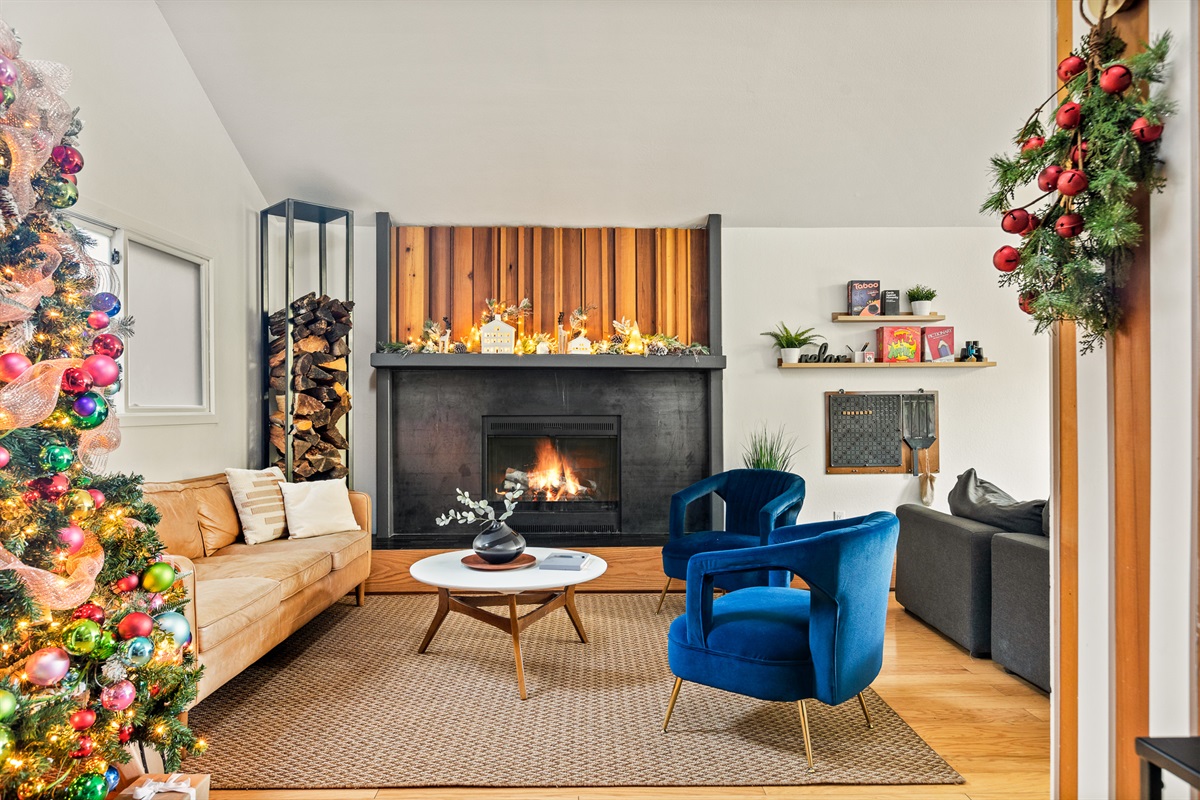 Cozy mountain cabin fireplace with warm holiday decor, glowing fire, and modern wood accents—perfect for a relaxing winter getaway in Lake Arrowhead.