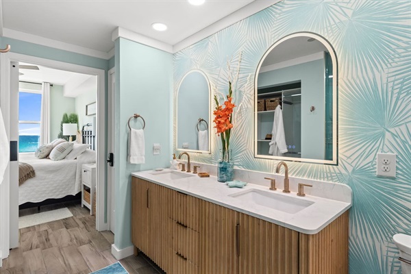 LED & Anti-Fog arched mirrors over a fluted wood vanity with quartz countertops