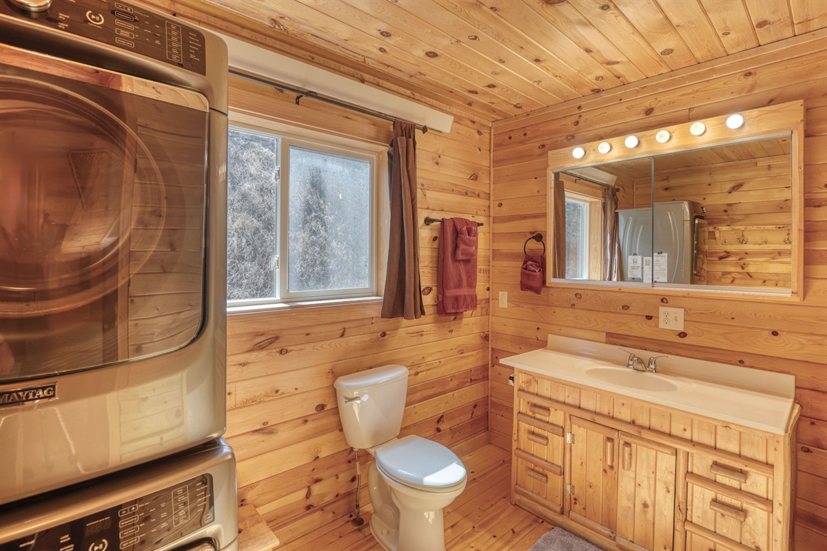 Bathroom with bath and washer and drier