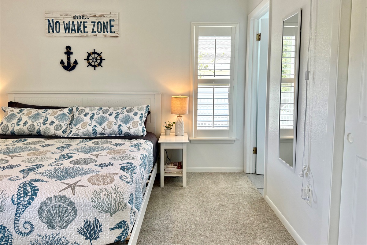 This primary suite offers a calming coastal vibe, perfect for unwinding after a beach day.