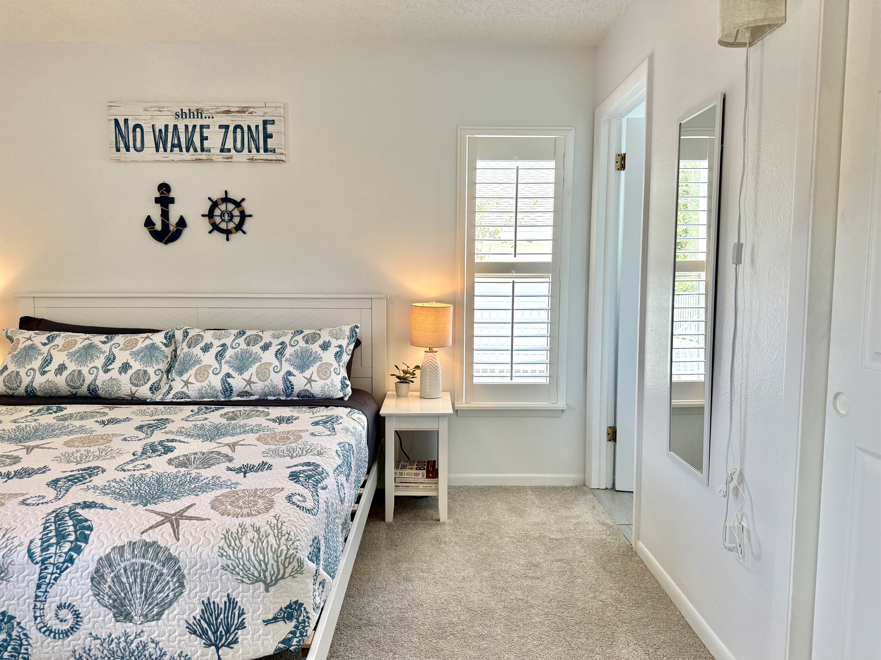 This primary suite offers a calming coastal vibe, perfect for unwinding after a beach day.