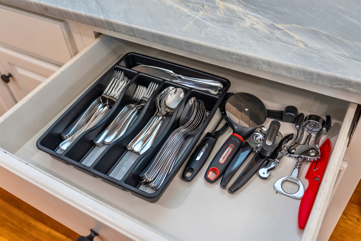 A drawer filled with silverware and utensils keeps everything you need within reach for a convenient dining experience.