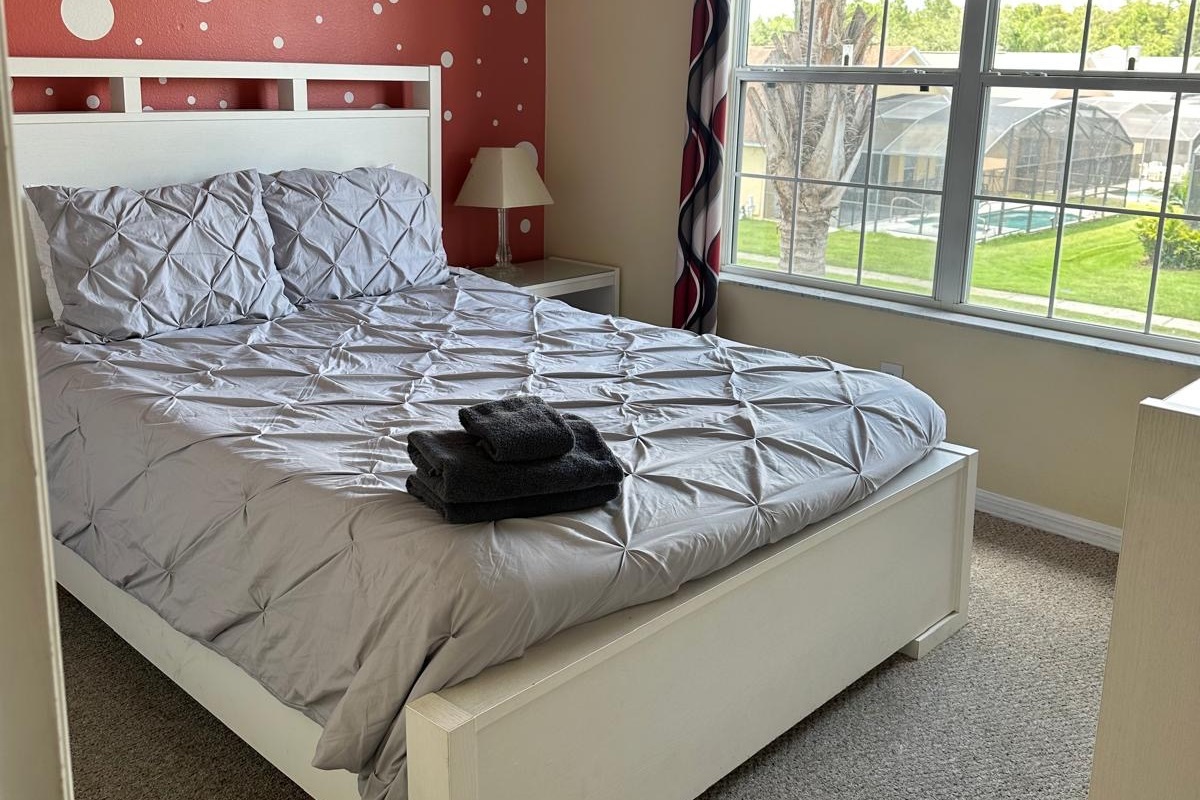 Bedroom #5 with queen size bed, TV, dresser. New decor 2025.