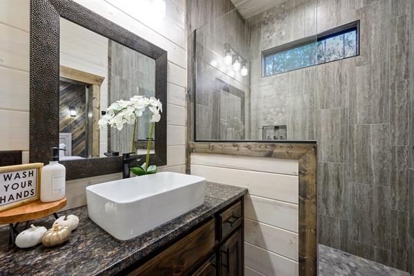 Modern spa ensuite with a vessel sink and luxury walk-in stone shower.