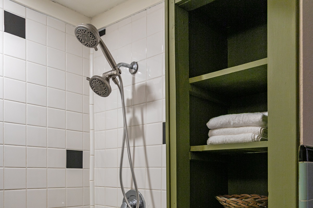 The upstairs bathroom features a walk-in shower with dual shower heads, offering both comfort and convenience.