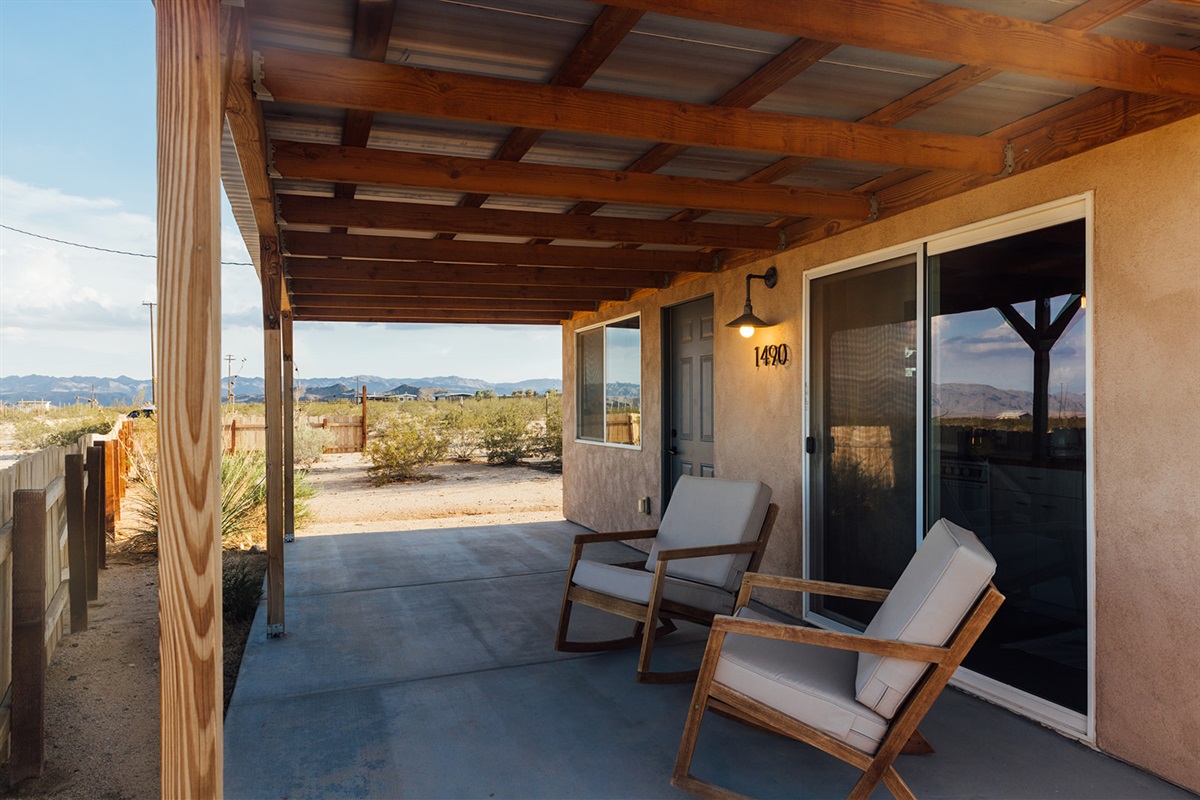 Side deck with shaded seating and desert views, ideal for lounging or unwinding in the quiet Joshua Tree landscape.