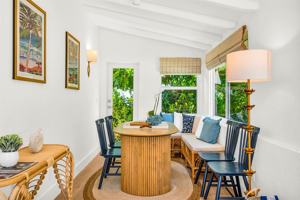 Sun-drenched sophistication—this inviting Florida room features seating for six, a chic bar cart, and panoramic pool views framed by bamboo woven shades. Perfect for intimate meals, morning coffee, or evening cocktails with a tropical backdrop.