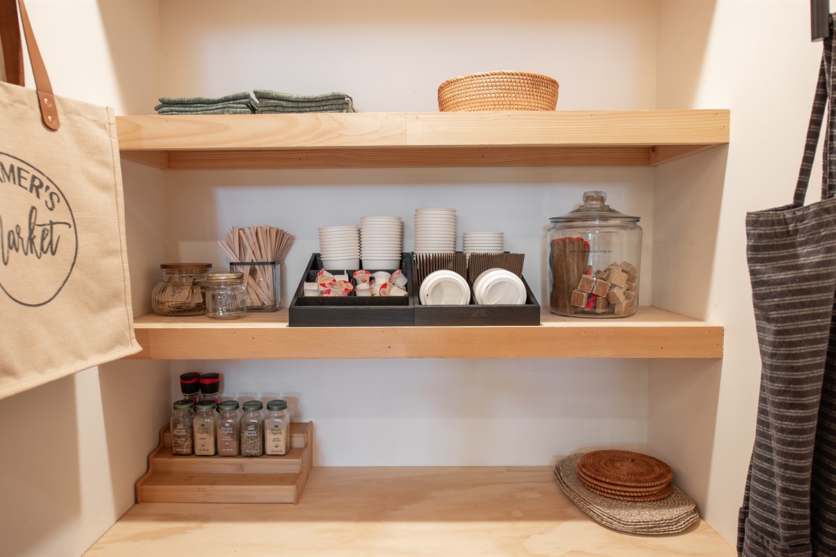 Tucked just off the kitchen, this pantry station is stocked with essentials, mugs, and cozy touches that make you feel instantly at home.
