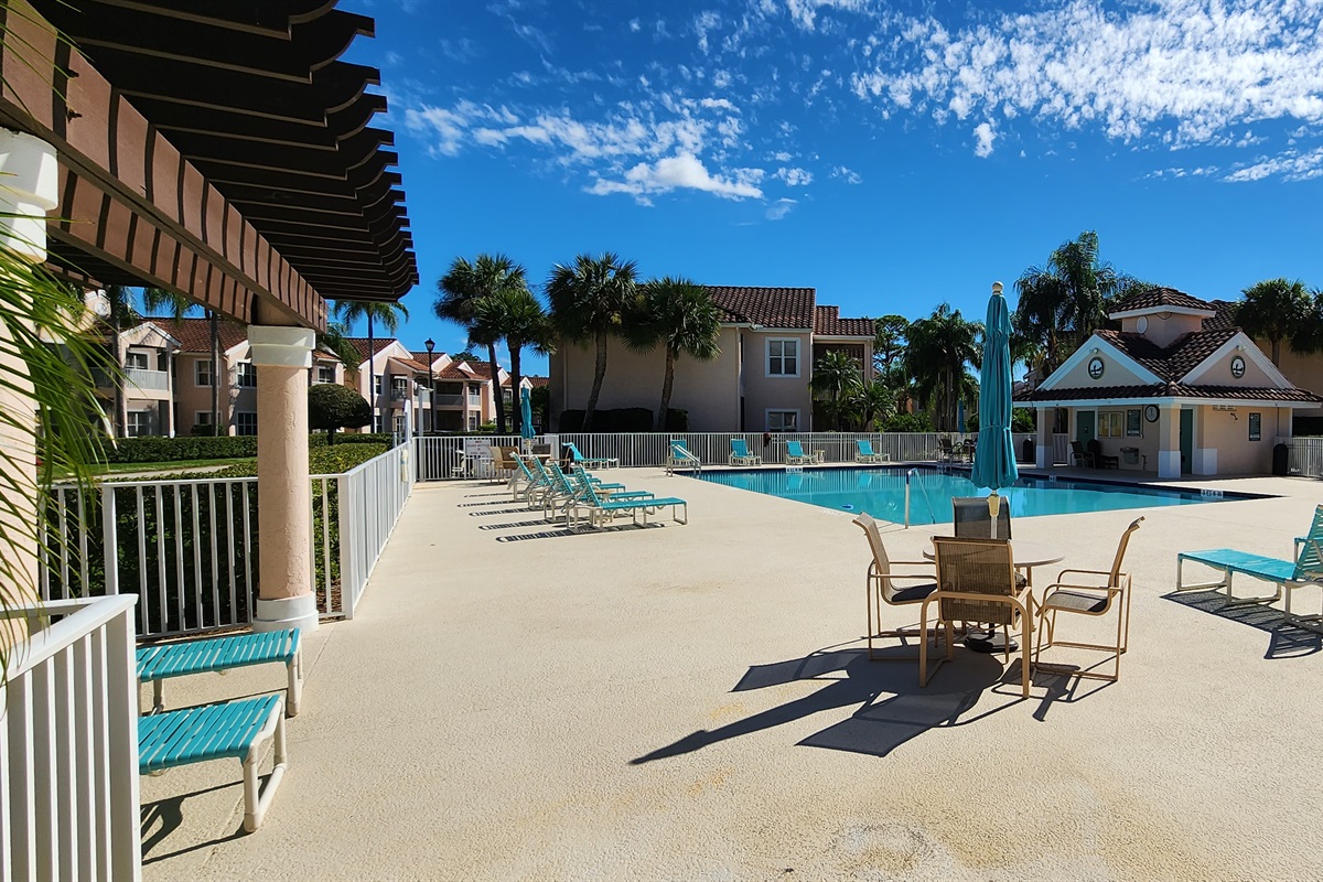 Community pool area with lounge seating, shaded spaces, and a relaxing outdoor setting.