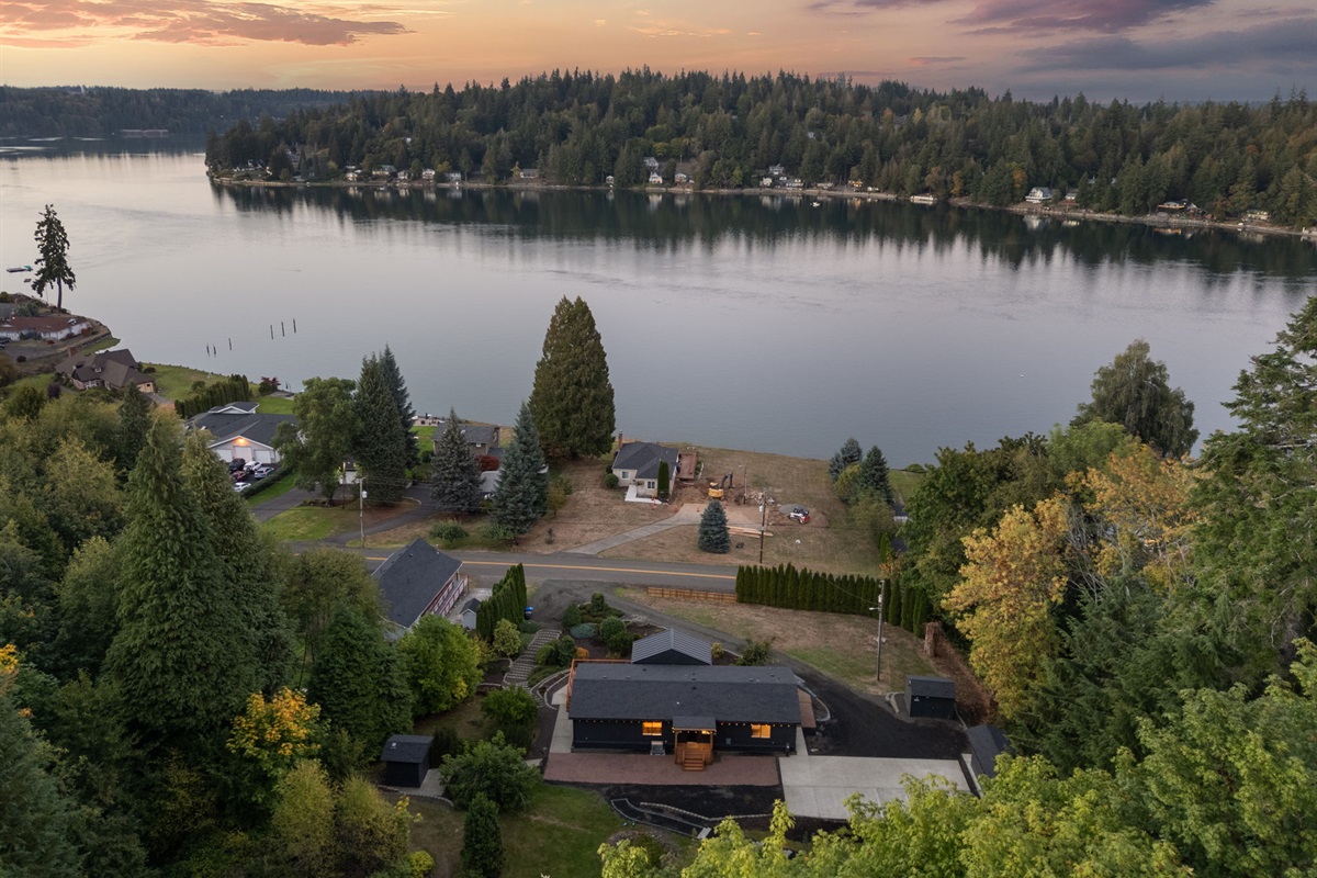 A bird’s-eye view captures the home’s quiet beauty framed by the inlet at dusk