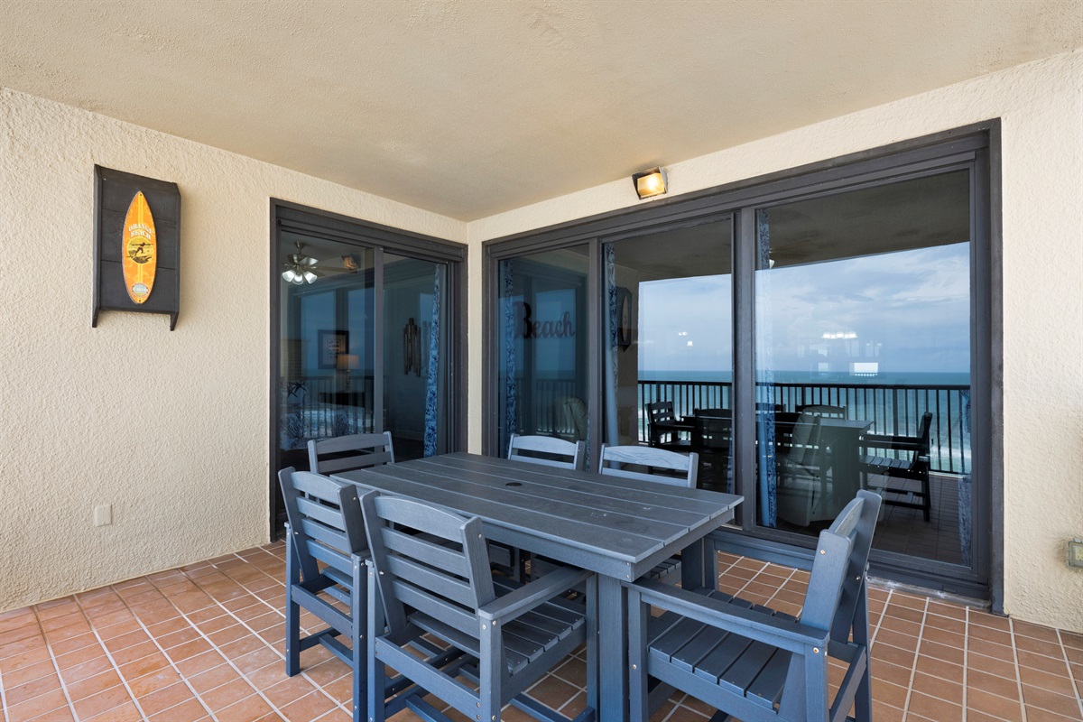 Balcony with Polywood table and chairs that is accessed from the living room and primary bedroom