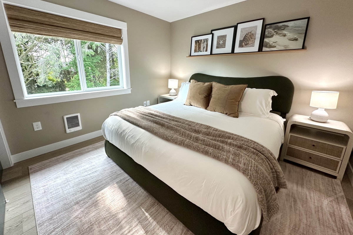 A second king bedroom in a calm, coastal palette — quiet, restful nights after a full day at the beach.
