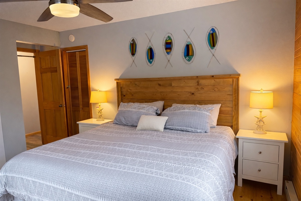 Primary king bedroom on the main floor with cozy nightstands, warm bedside lamps, and an easy layout for a great night’s sleep after a day on the North Shore.