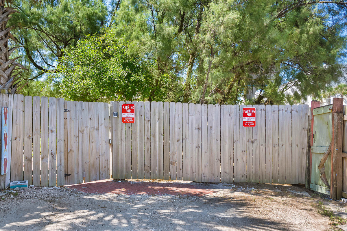 The fenced boundary of the property, clearly marked and private. Beyond it runs the sandy path towards the dunes; behind it sit your patio, the shared hot tub and the fire pit waiting for the evening.