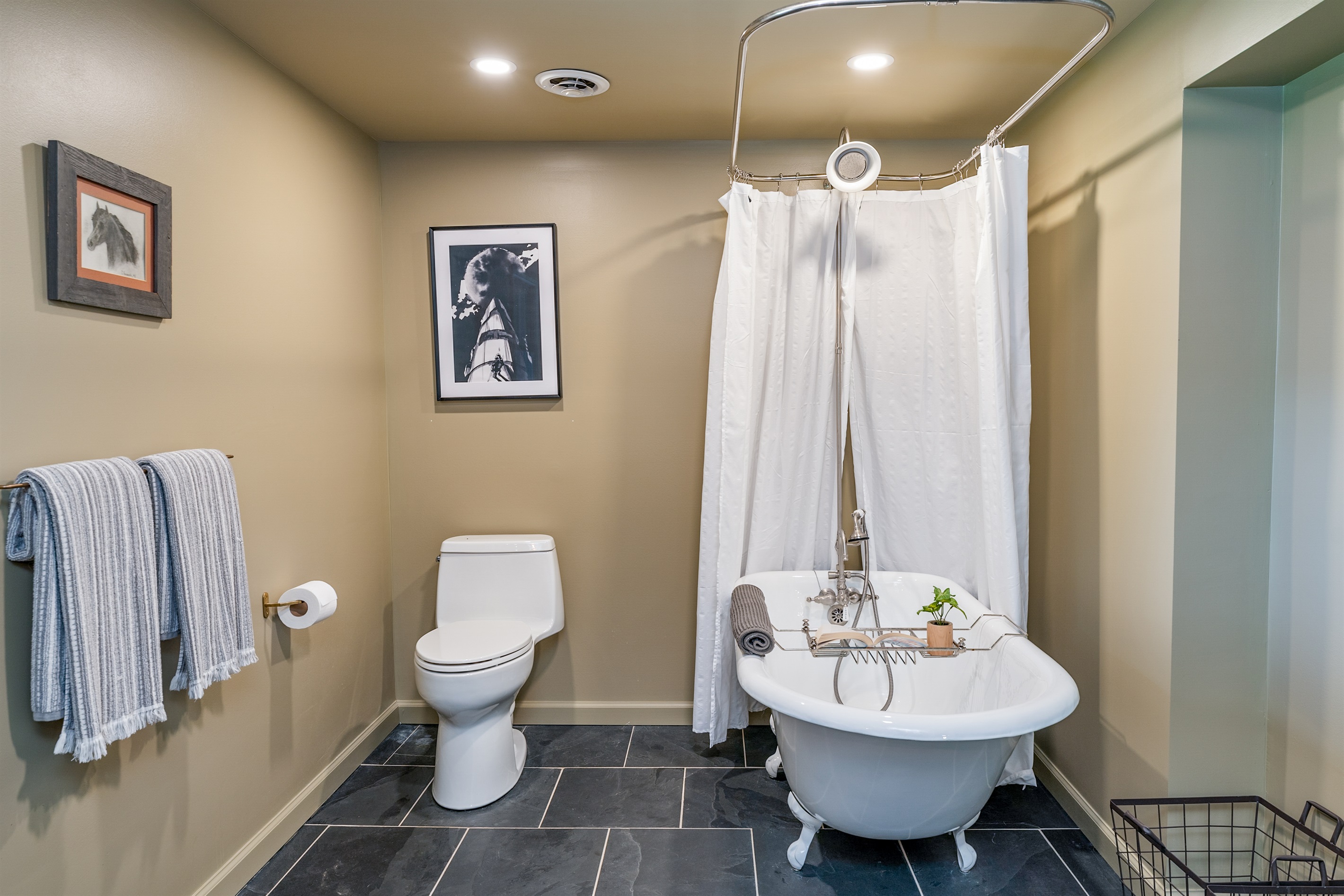 Unwind in this charming clawfoot tub with shower, set in a spacious bathroom offering lake views and serene comfort