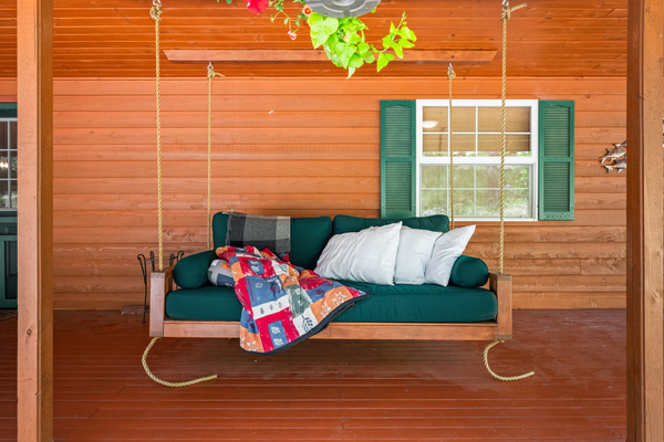 Twin-sized hanging day bed on the front porch inviting you to lounge