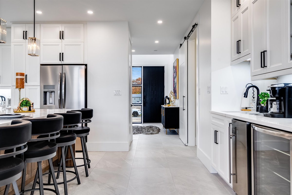 A chef's dream kitchen with extra large eat-in island and high-end appliances including gas stove and two ovens.