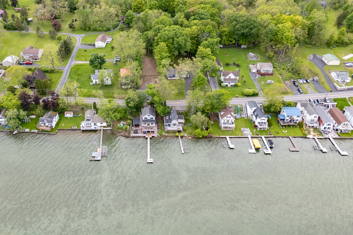 Aerial shot showcasing expansive lakefront entertaining space, hot tub, and private dock for the ultimate getaway 🎯🌊🍹
