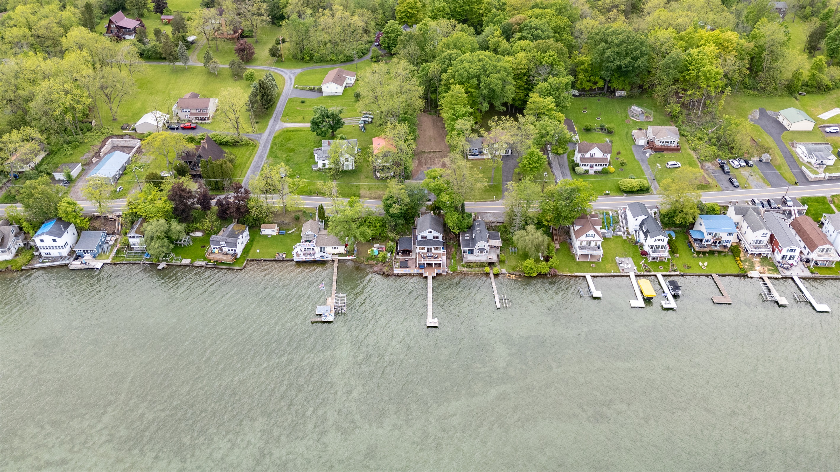 Aerial shot showcasing expansive lakefront entertaining space, hot tub, and private dock for the ultimate getaway 🎯🌊🍹