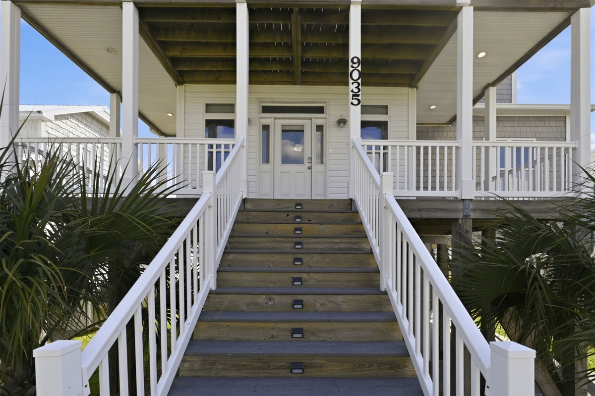 Welcoming elevated entryway with covered porch and classic coastal charm